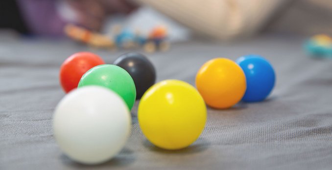 Sensorik-Übungen mit bunten Kugeln in der Bobath-Therapie.